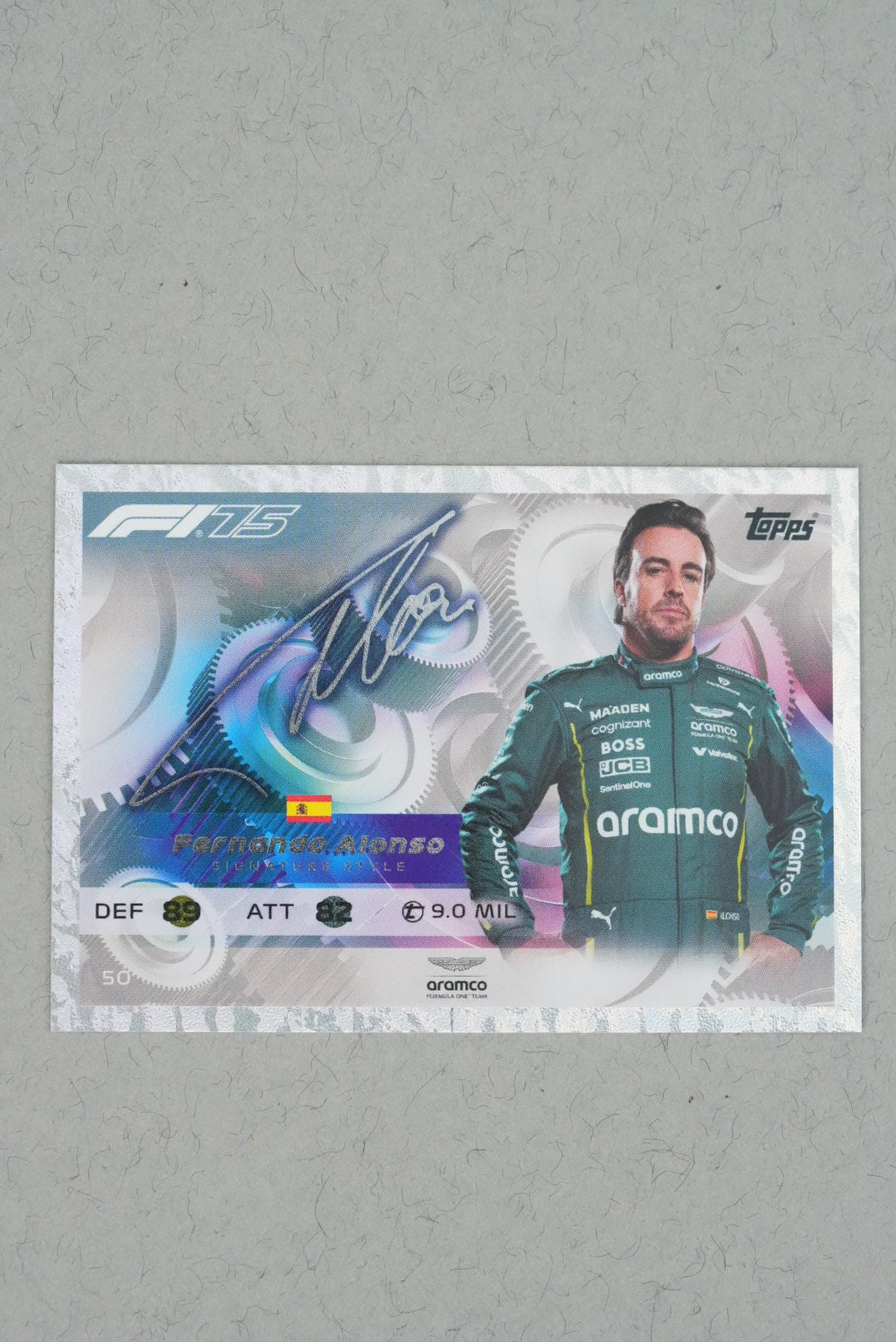 F1 trading card featuring a driver in a green racing suit with 'Aramco' on a gray background